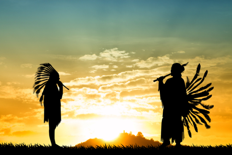 American Indians playing music at sunset