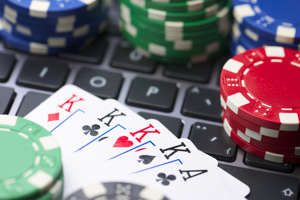 poker chips and cards on a laptop keyboard