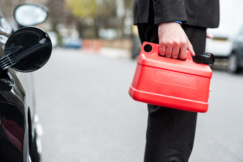 businessman holding plastic gasoline can