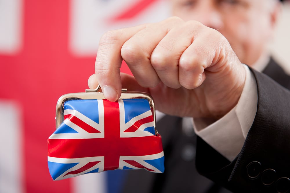 main in suit holding purse wrapped in a Union Jack print