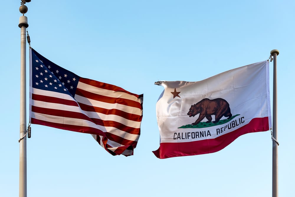 flags of the US and California on masts facing each other