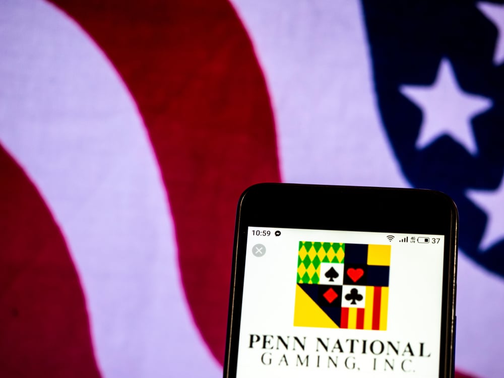 Penn National logo on cellphone with American flag in the background