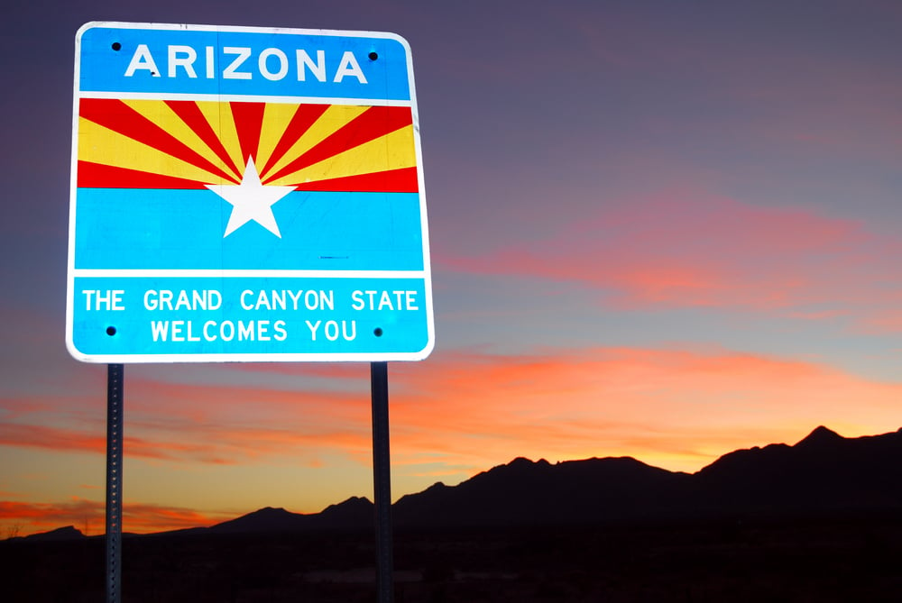 Arizona welcome road sign against a dusky pink sky