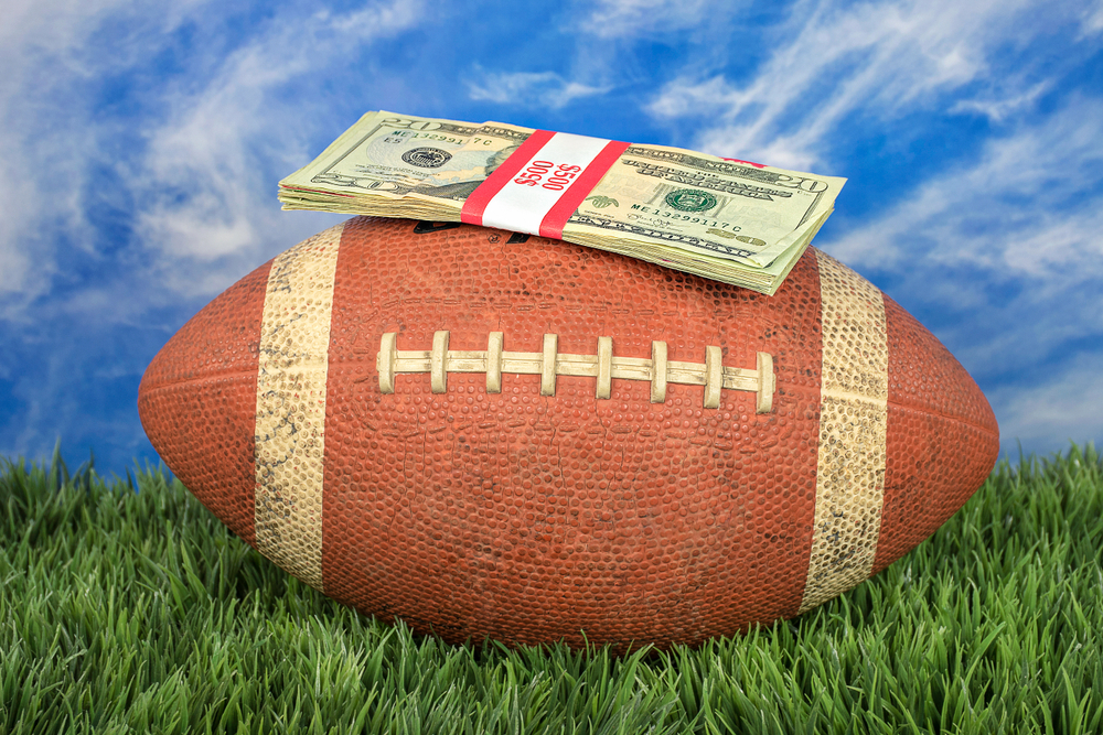 American football with wad of cash