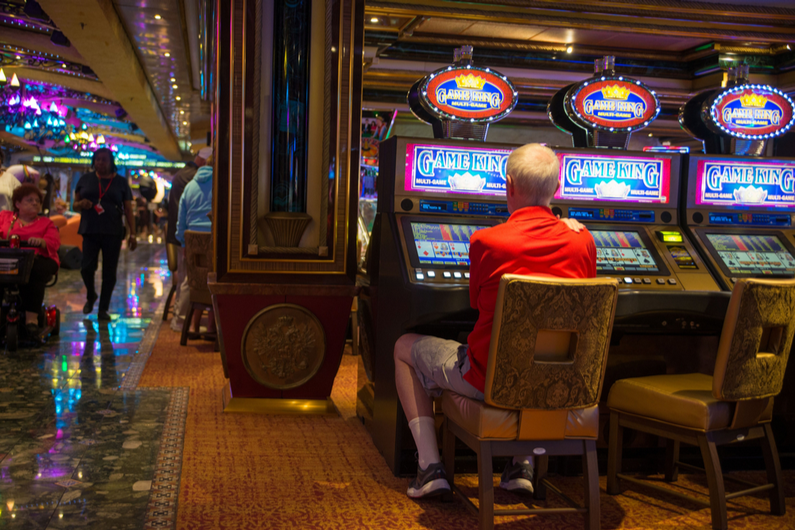 old man playing video poker